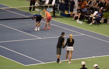 Hayden Christensen gets ready to toss the ball while holding hands with Aleksandra Wosniak for her serve in mixed doubles match November 17, 2011 tennis.