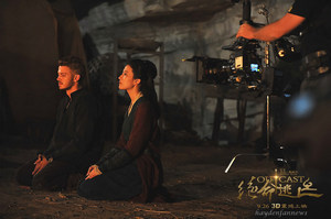 Hayden Christensen and Liu Yifei sit quietly by the fire in a scene from Outcast.